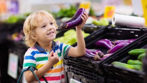 enfant qui tient une aubergine légume violet pour chasse au trésor par couleur