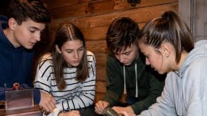 4 adolescents jouant à un escape game dans une salle thématisée