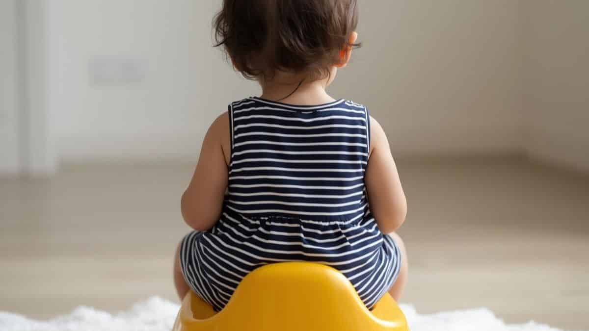 bébé habillé assis sur un pot